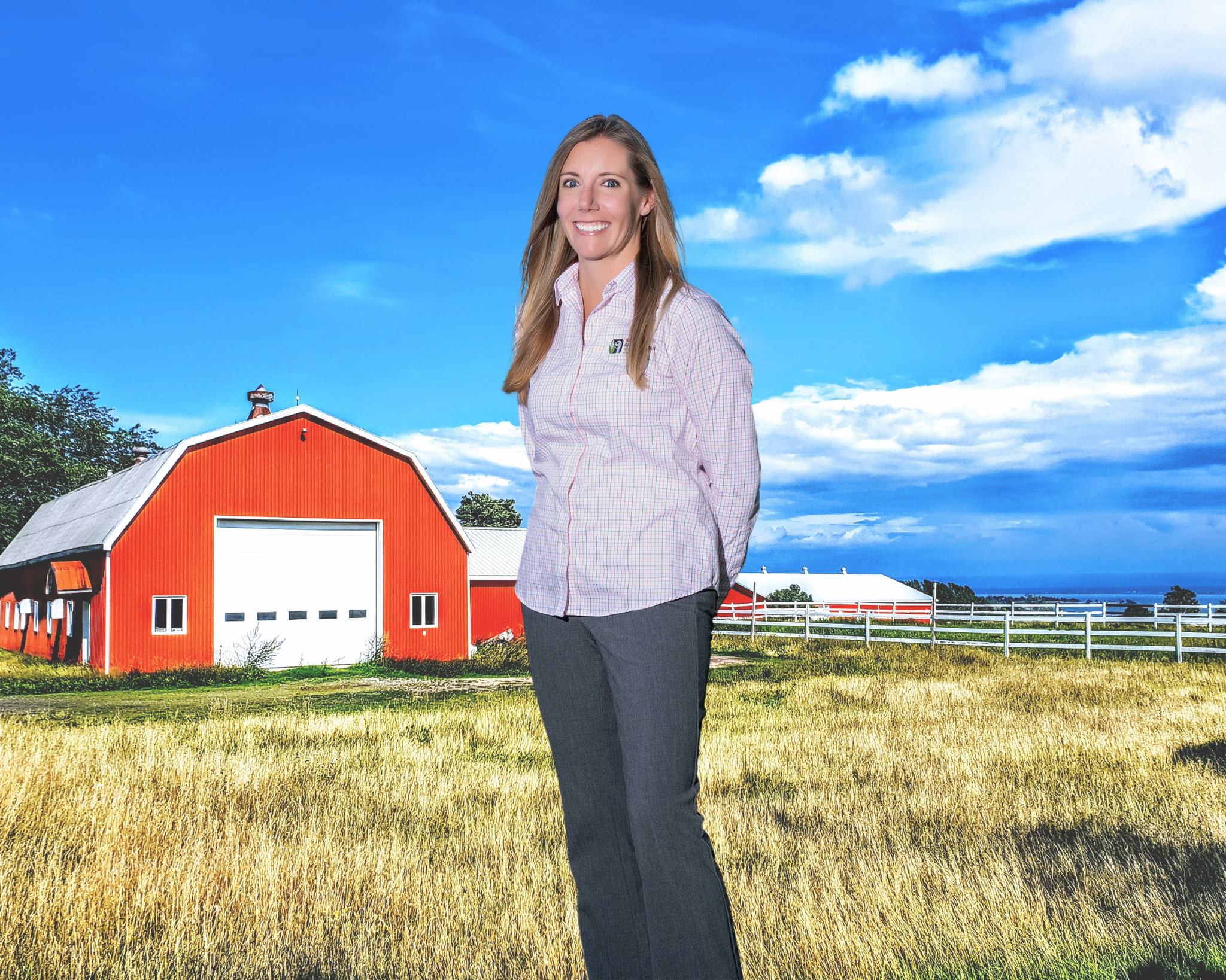 Pic of female loan officer standing in front of a barn and fence.