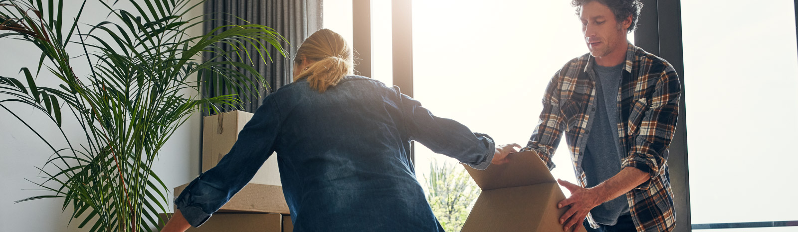 Man and woman moving boxes in home